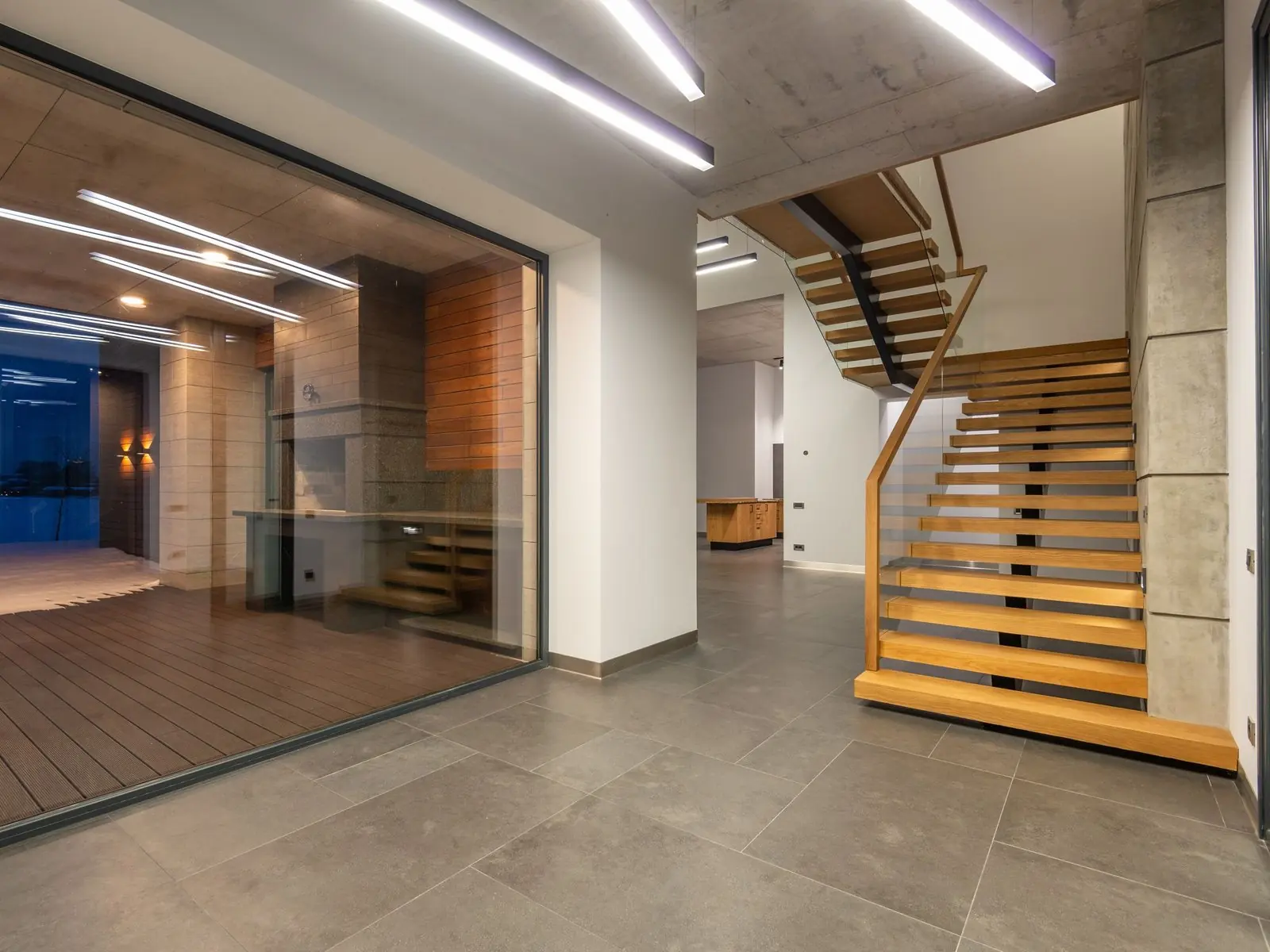 Hall con escalera de madera y ventanal