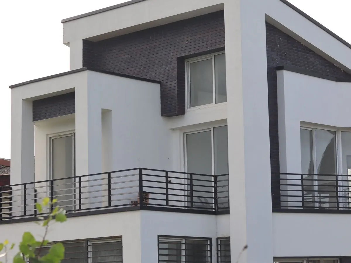Casa blanca de tres niveles con balcones